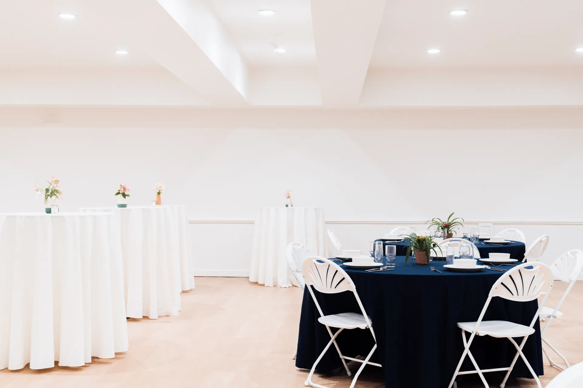A mix of high tops and standard round tables in a bright white space.