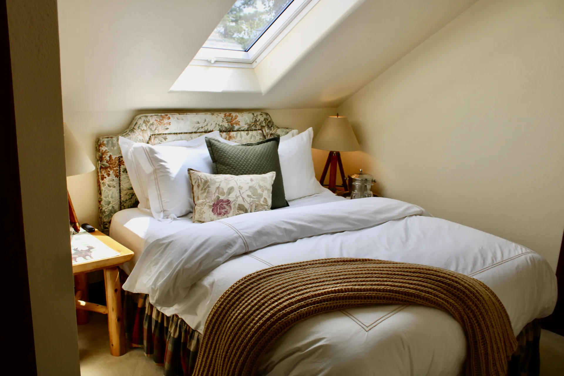 A sky light shining directly over a lush bed.