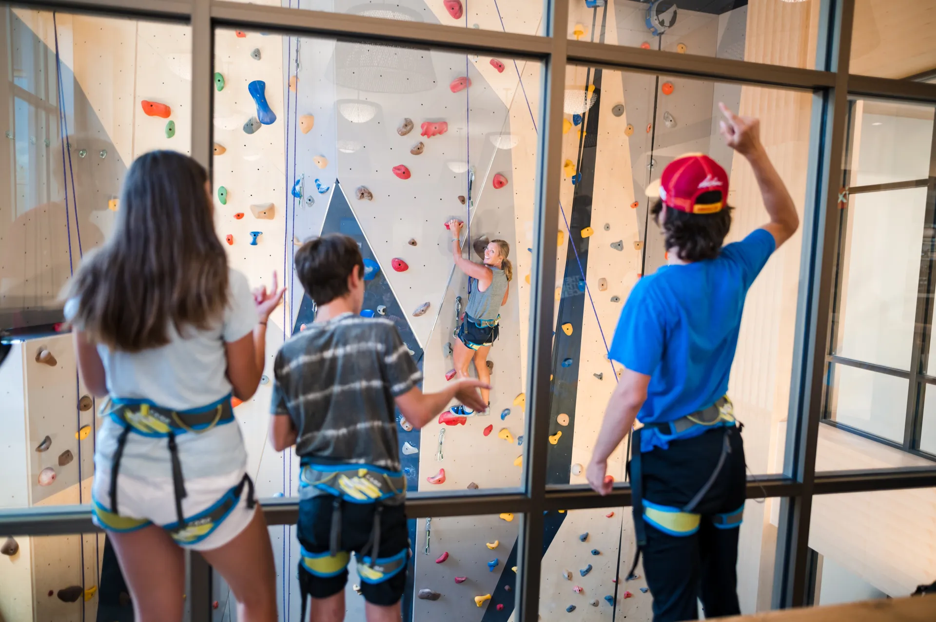 Family watches a family member climb the the climbing wall