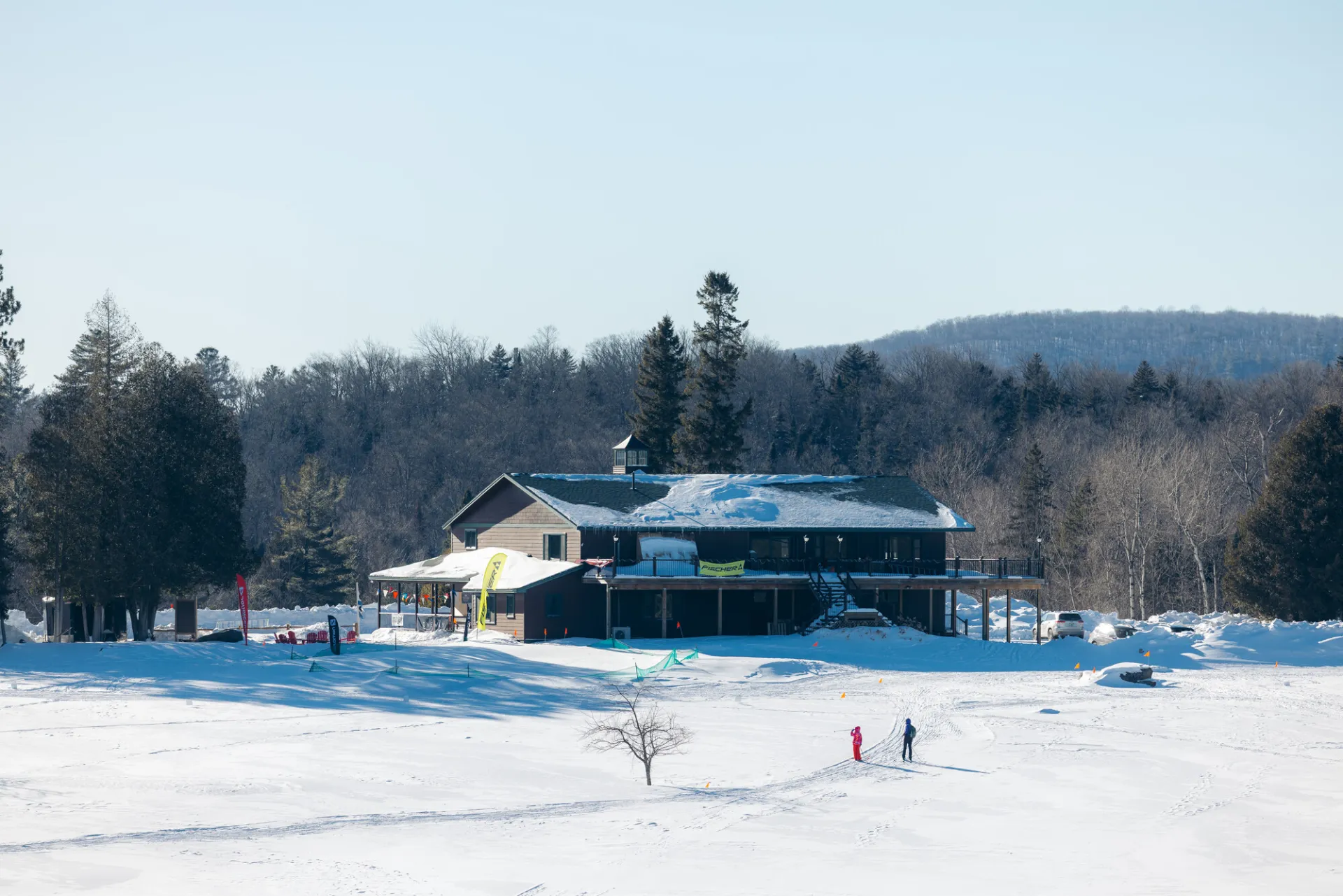 People cross country ski on a snowy golf course.