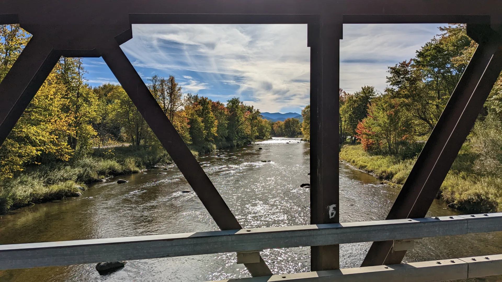 The view from a steel truss bridge over a river