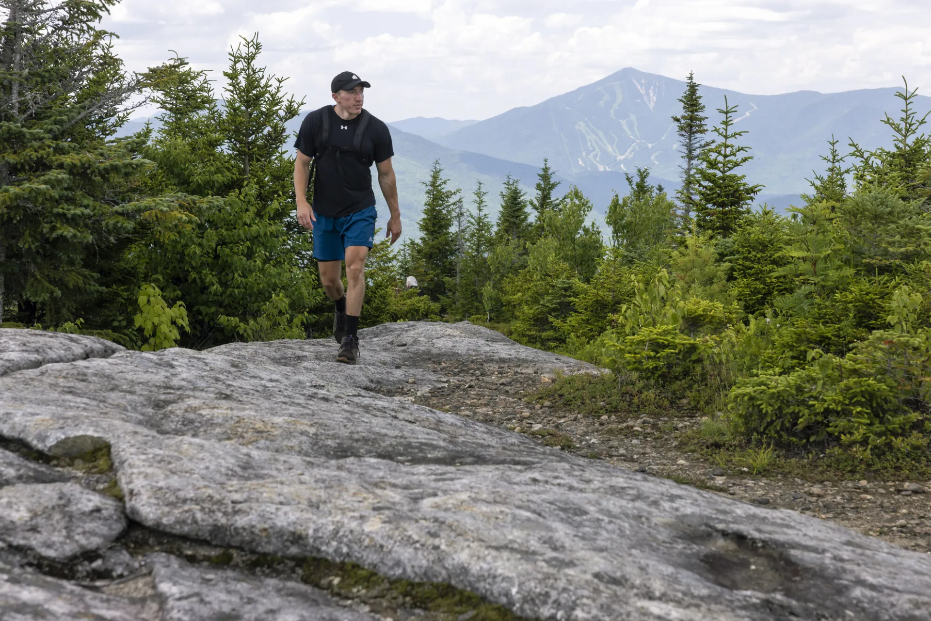 A hiker walks on a rocky summit