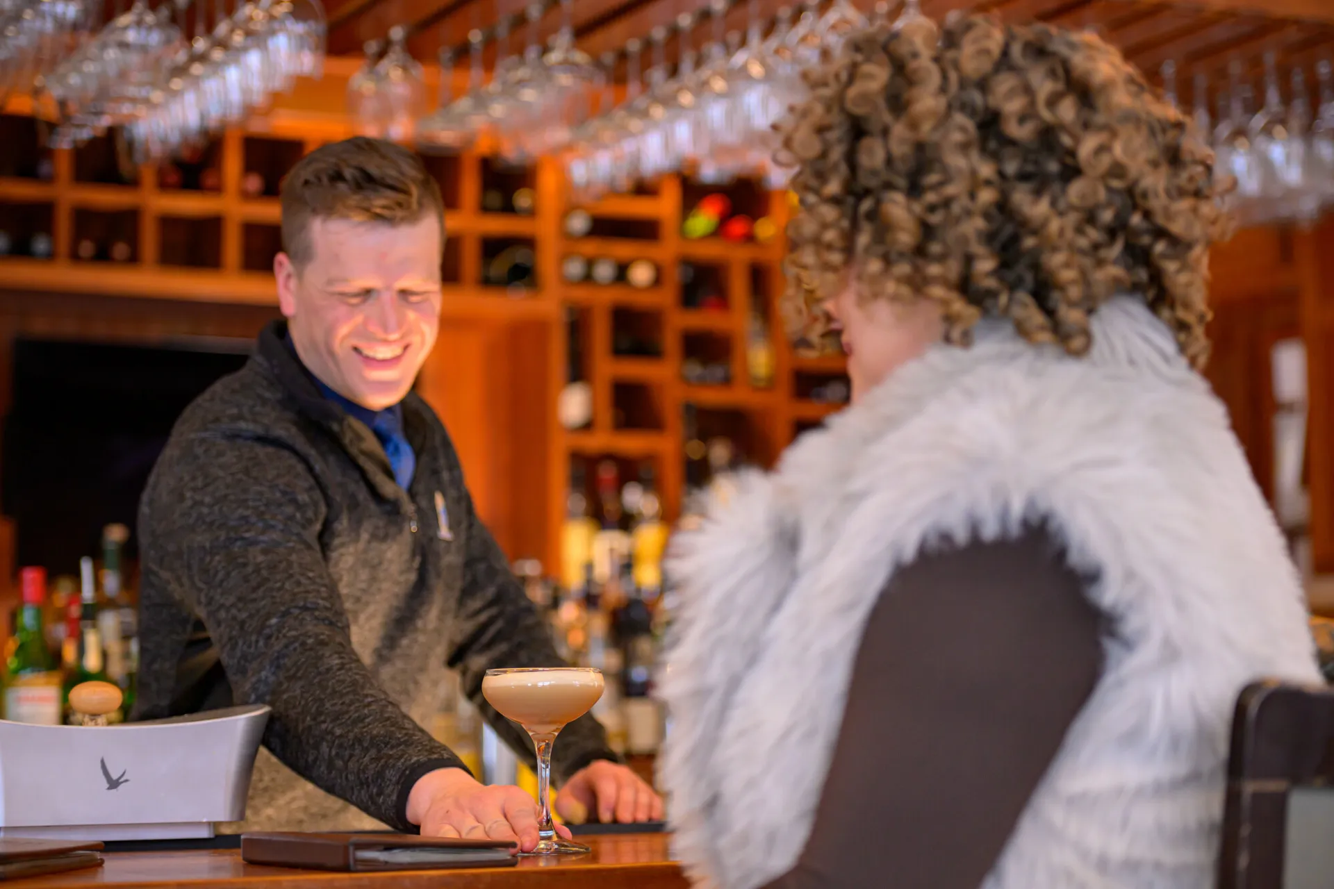 Bartender places drink in front of woman