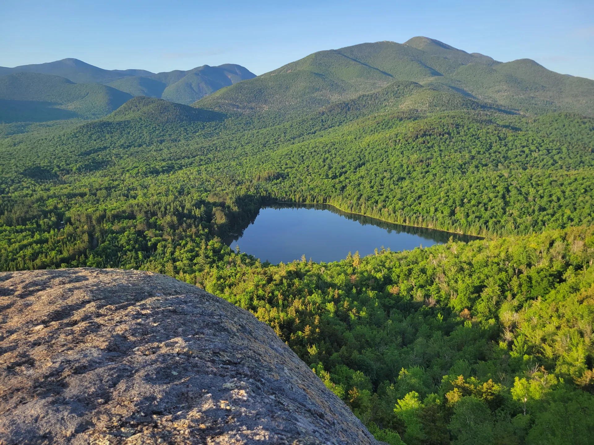 A small pond in front of tall mountains