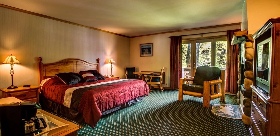 A large room with bed, chair & desk.