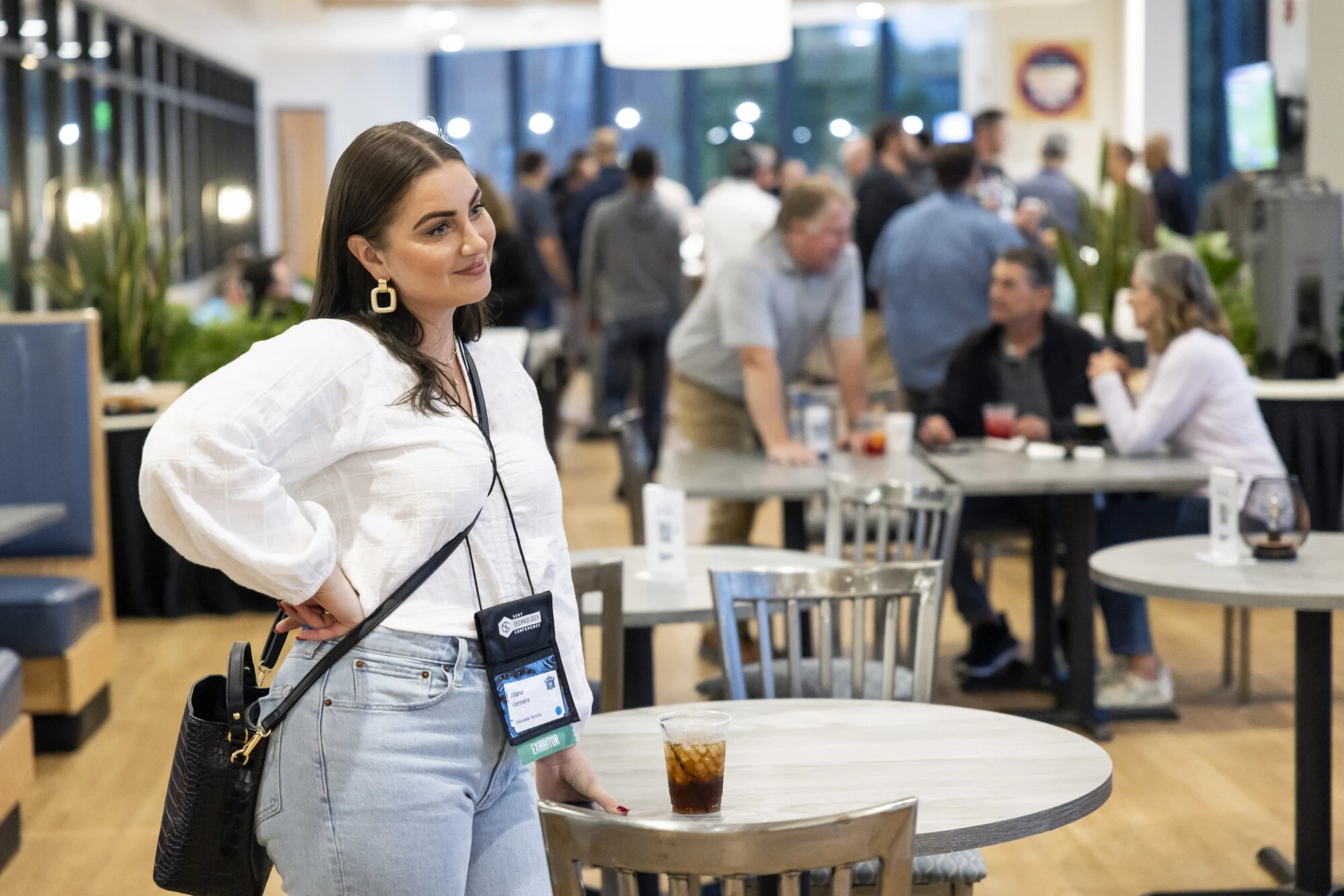 A woman smiles at a conference. 