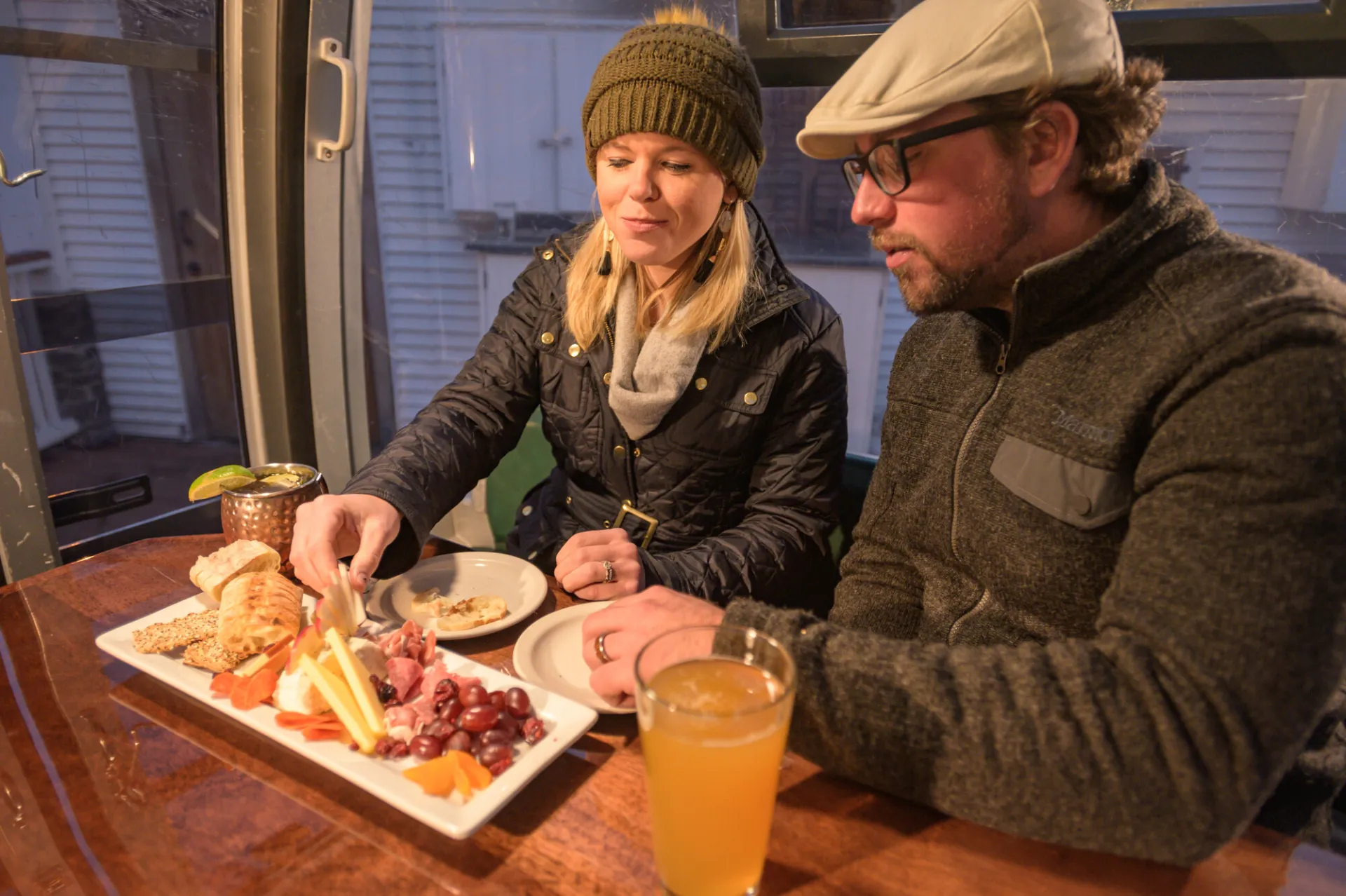 A man and woman share a charcuterie board.