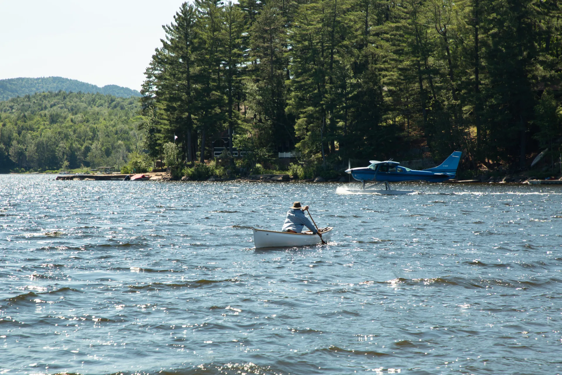 A person paddles out across a lake. 