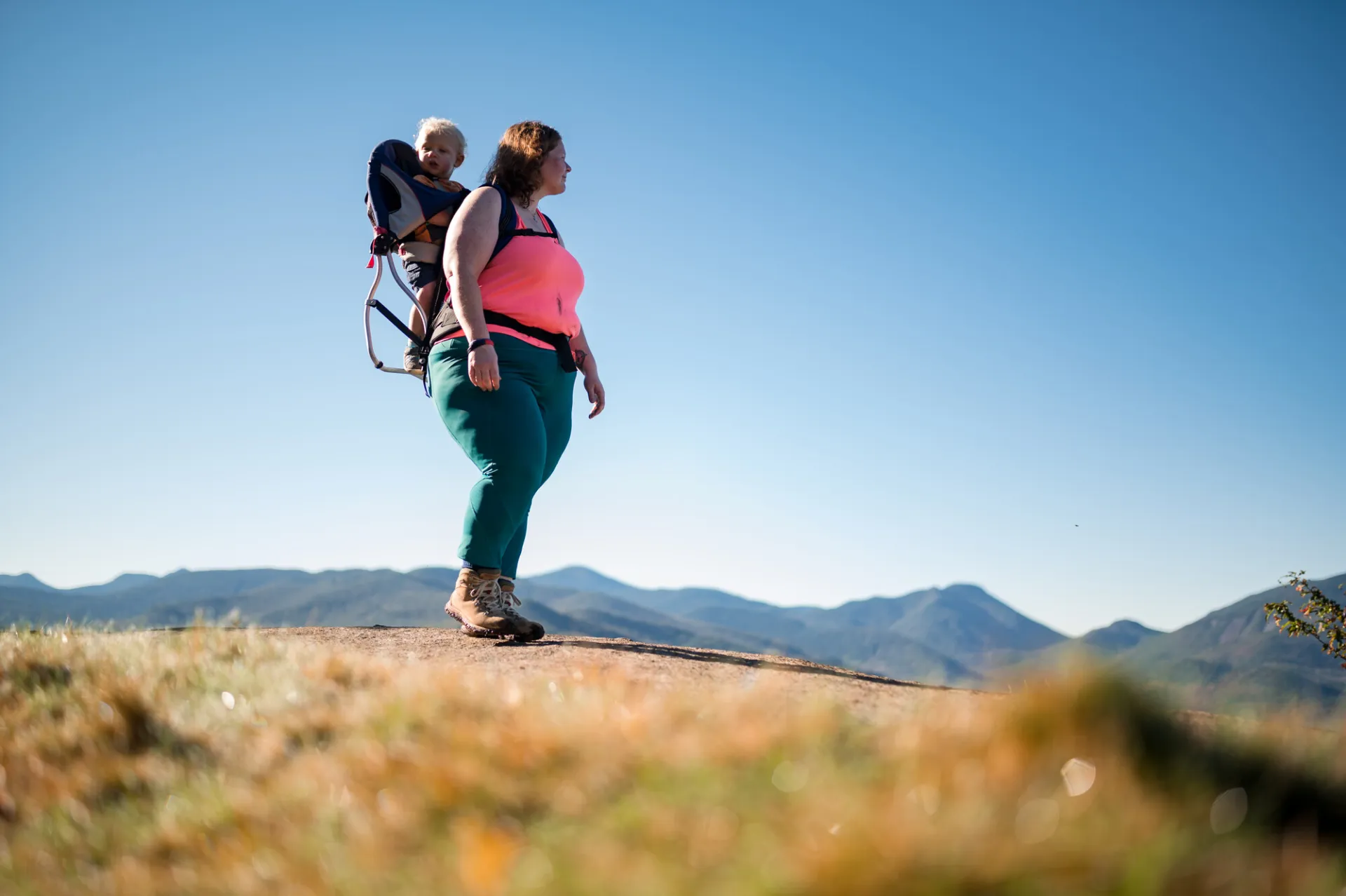 A mom hiking with her child in her backpack.