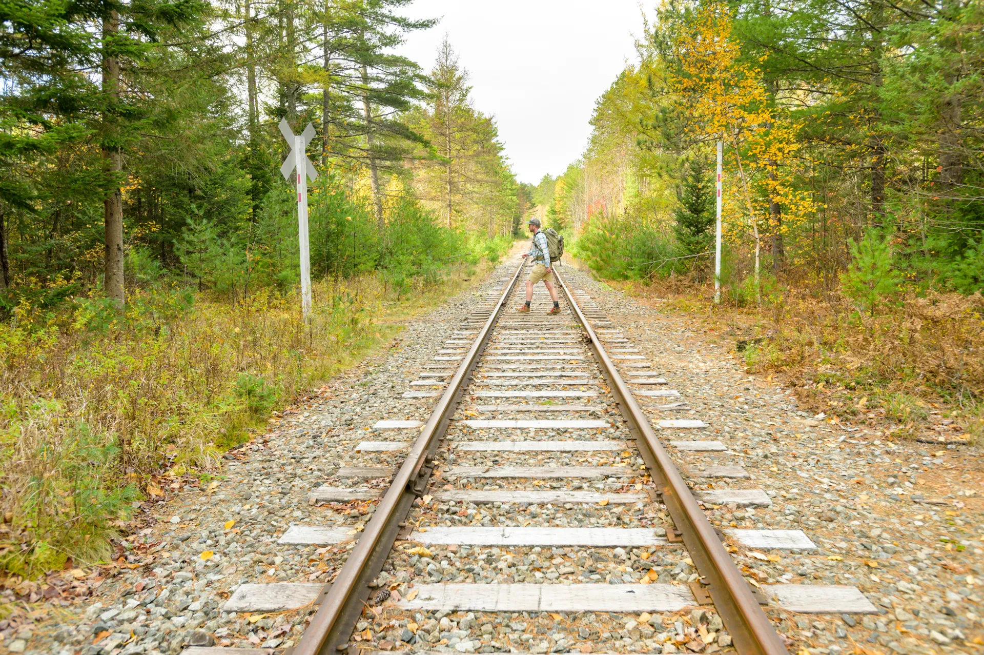 A hiker walking across a railroad