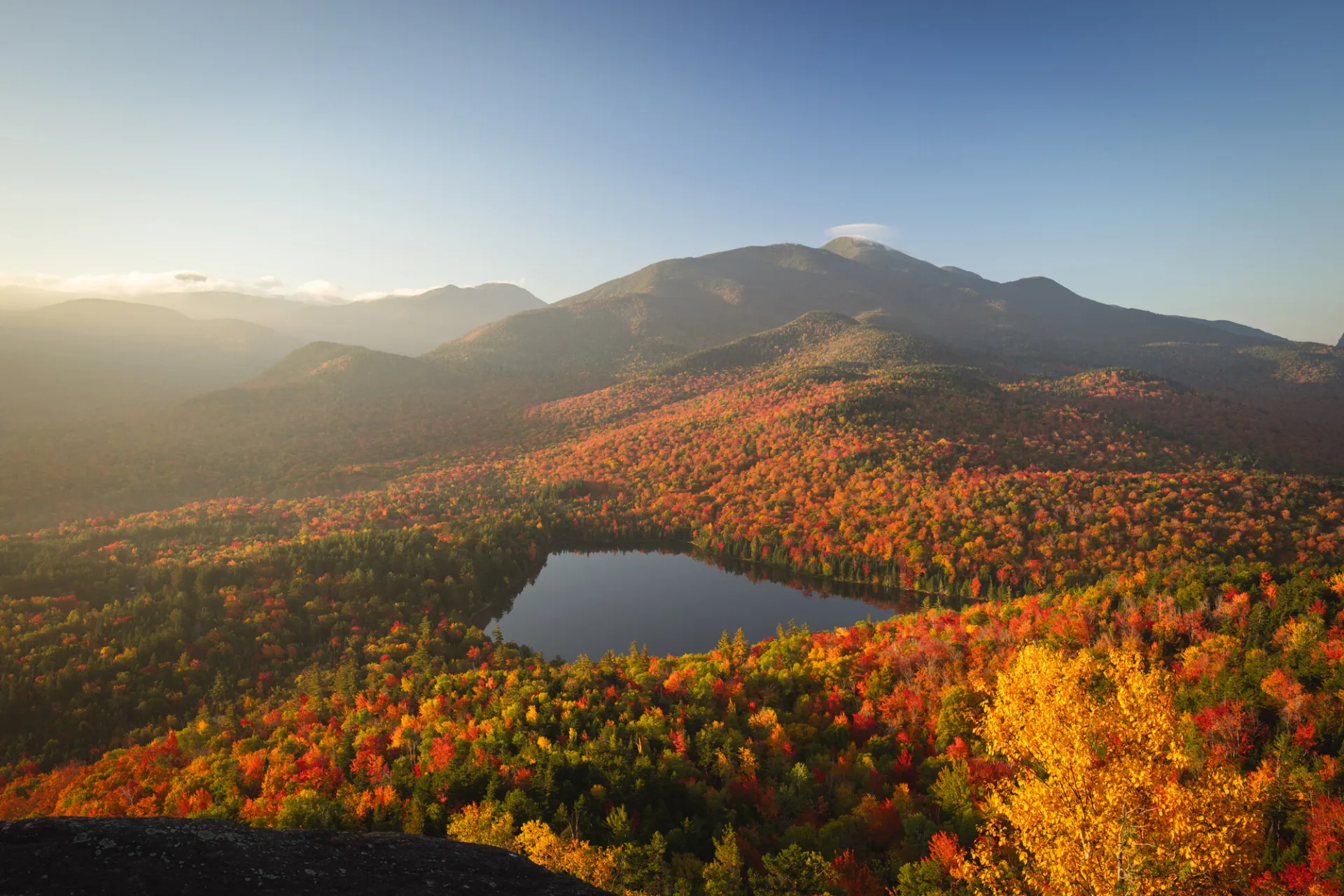 A view of a pond and mountains during the fall