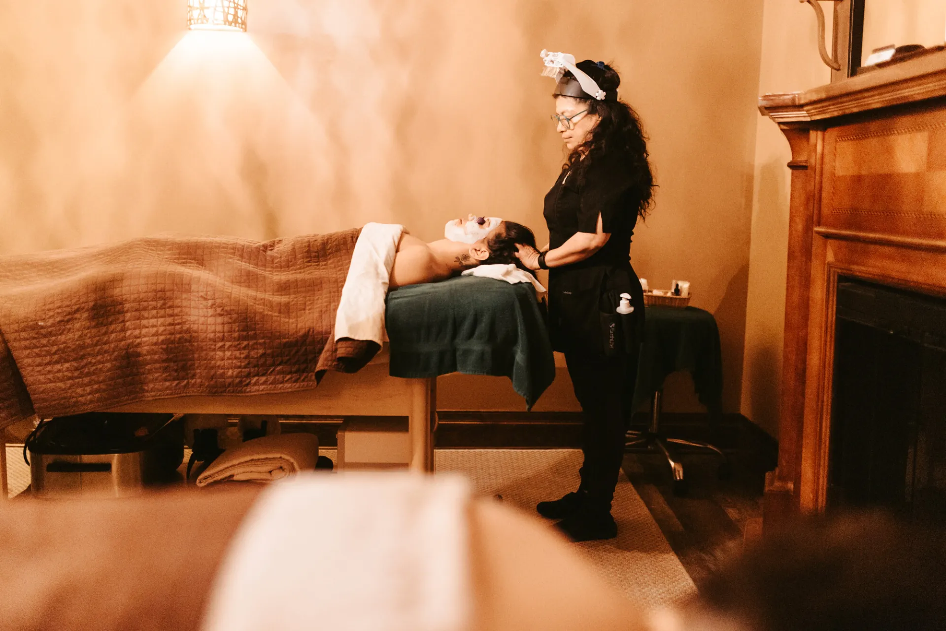 A woman recieves a facial treatment at a spa.