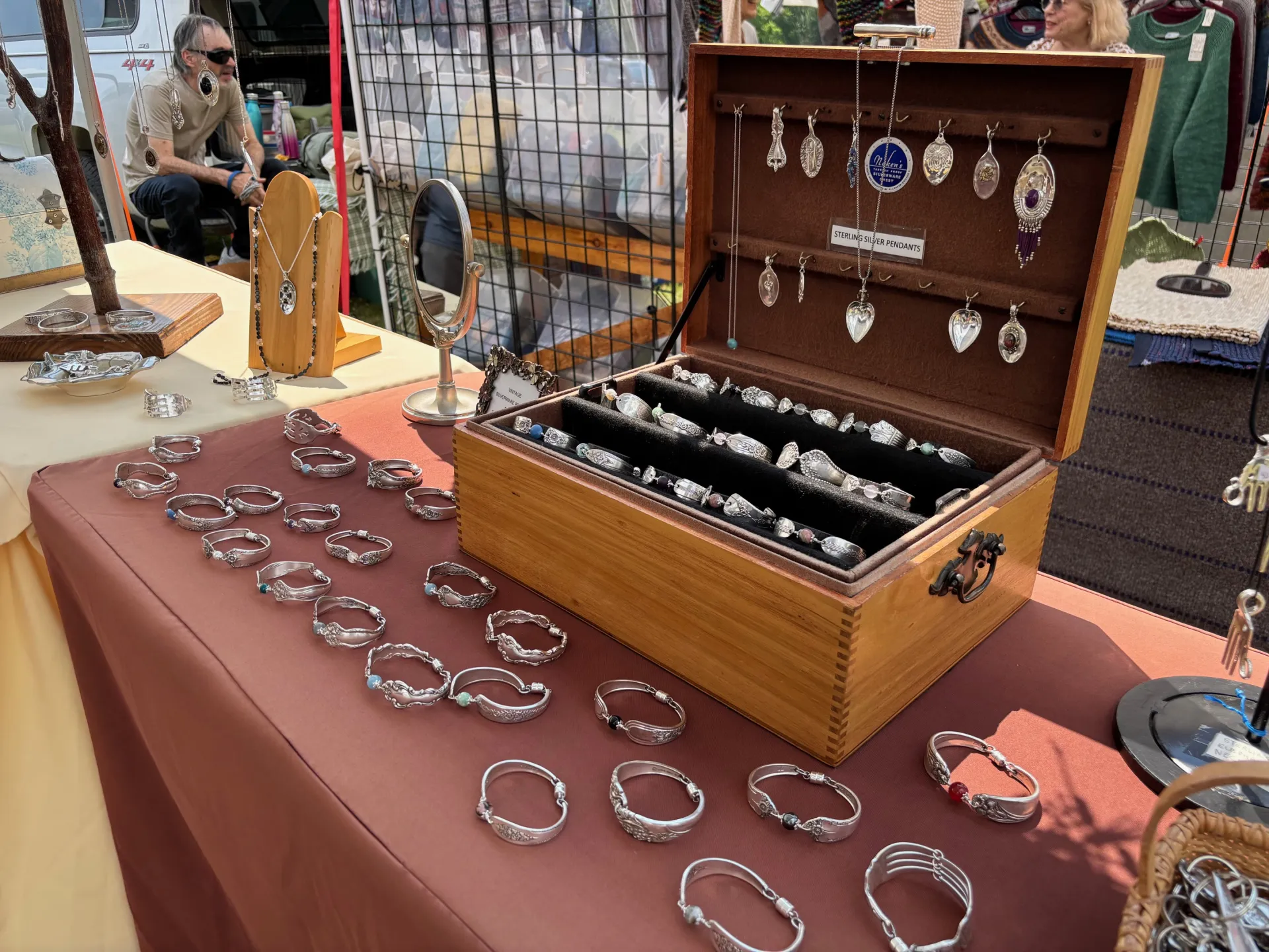 Bracelets, rings and necklaces made from old spoons are displayed in a jewelry box