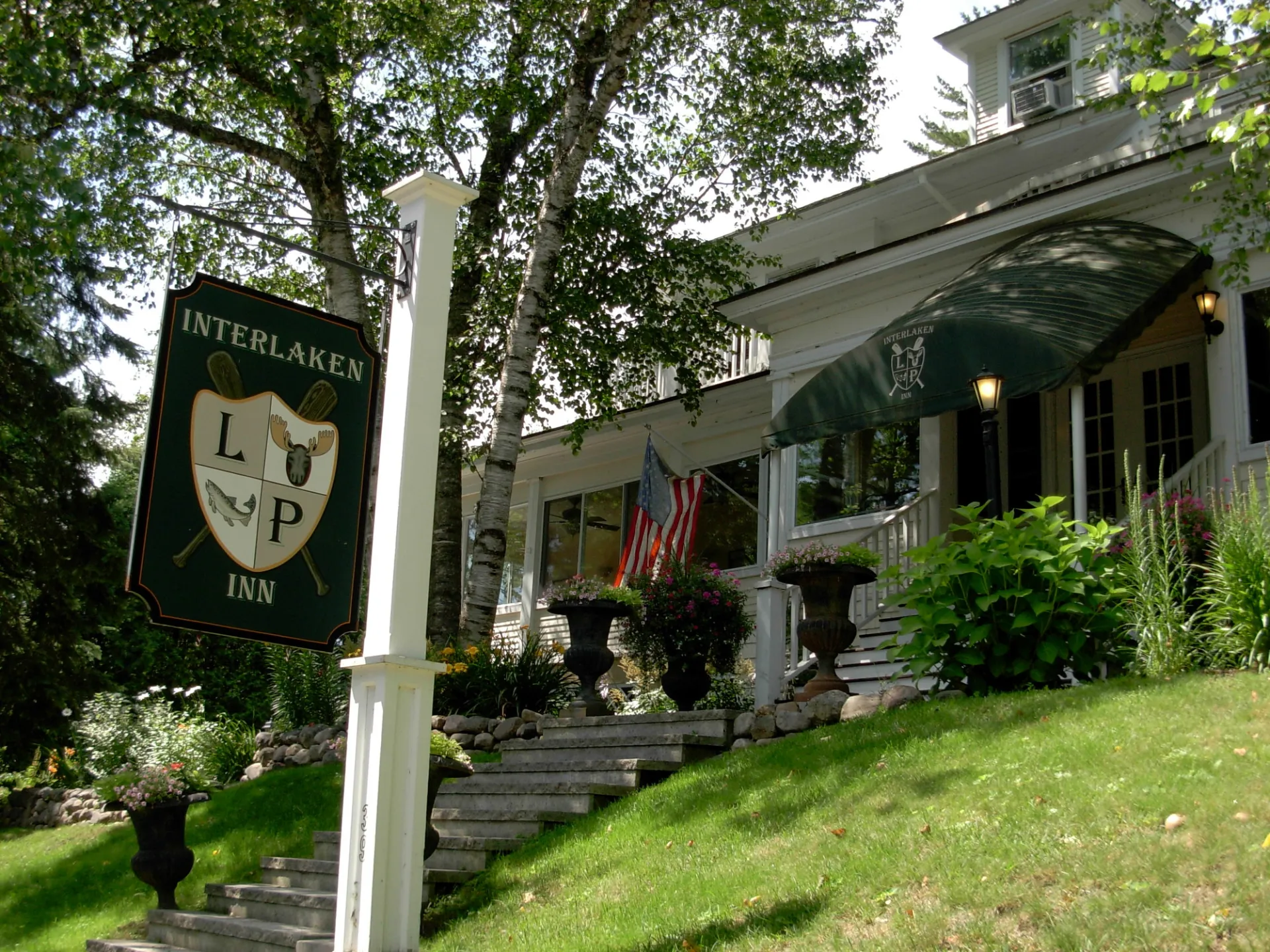 The front of a white hotel on a hill. 