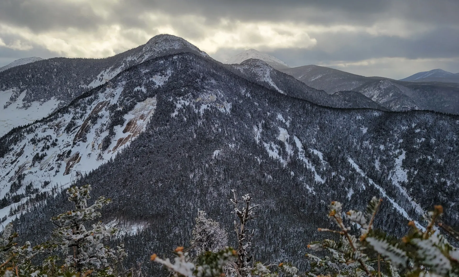 View of a tall mountain with rock slides covered in snow