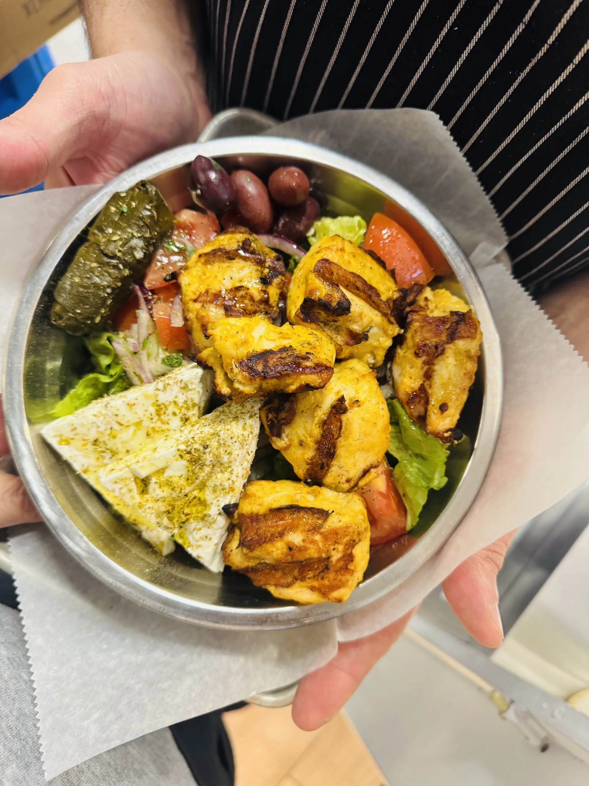 Greek salad topped with grilled chicken