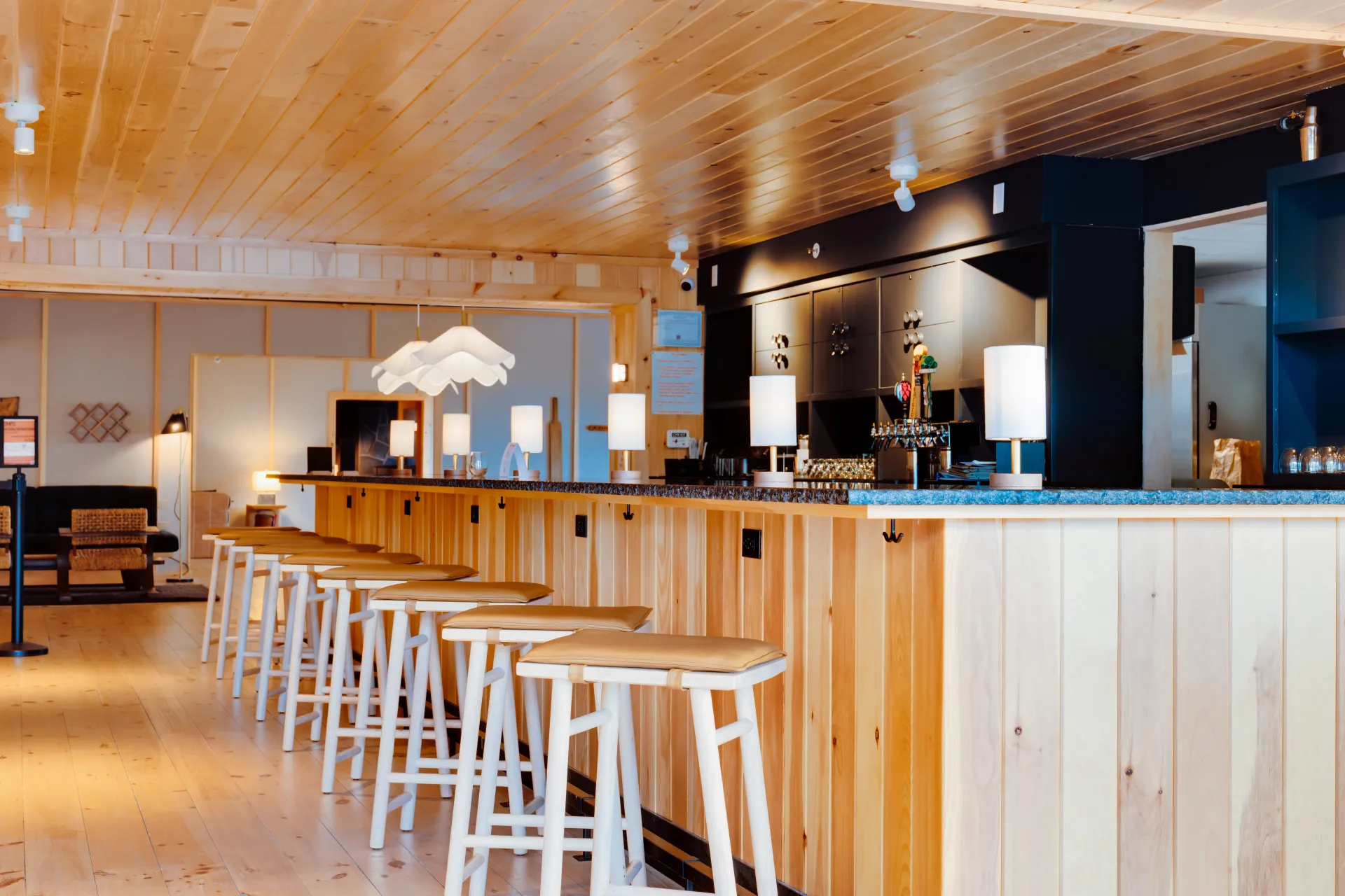 A bright bar space with wood and dark counter