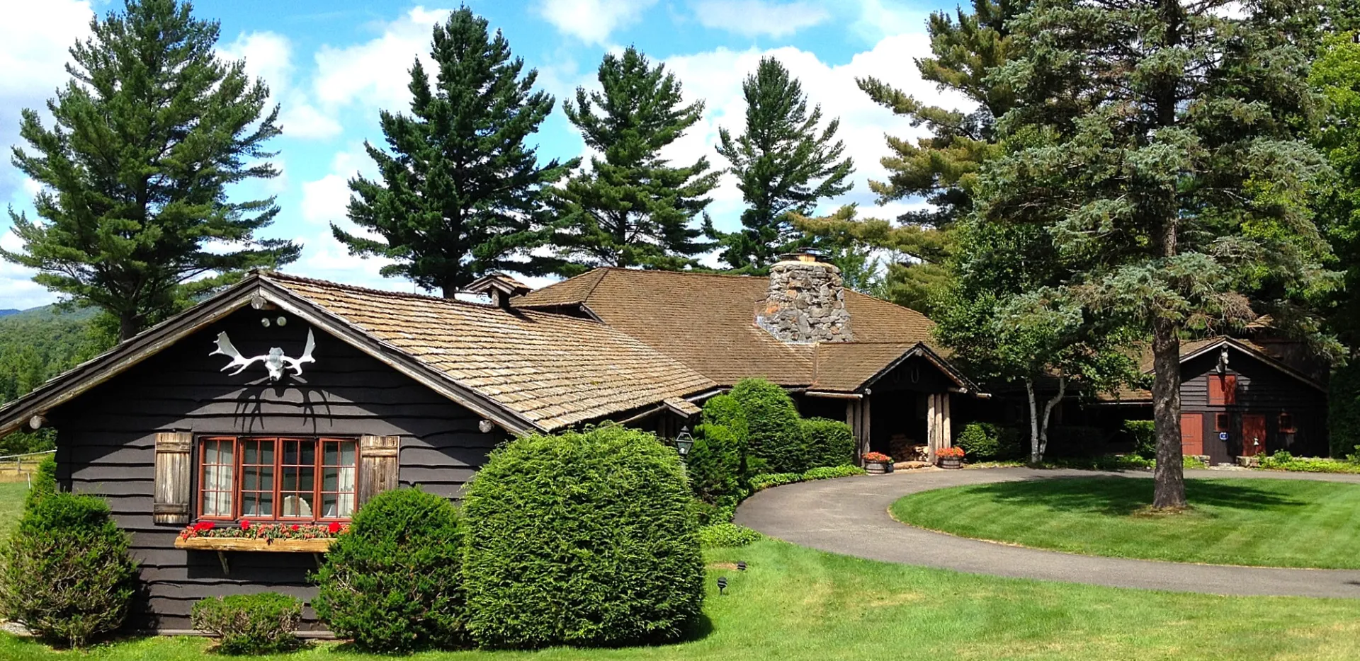 Side view of the home with circular driveway and landscaping.