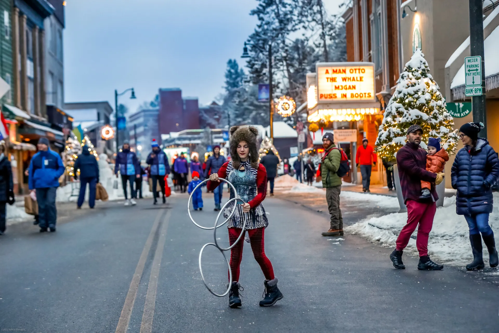 A woman dances with giant rings at a Main Street event in Lake Placid in winter. 