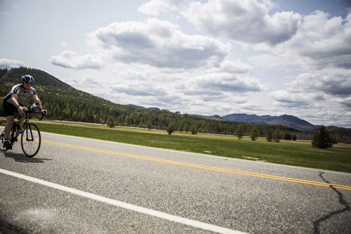 A cycler rides down a road