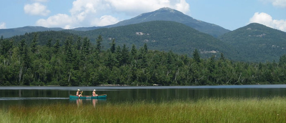 Two people in a canoe in a mountain pond