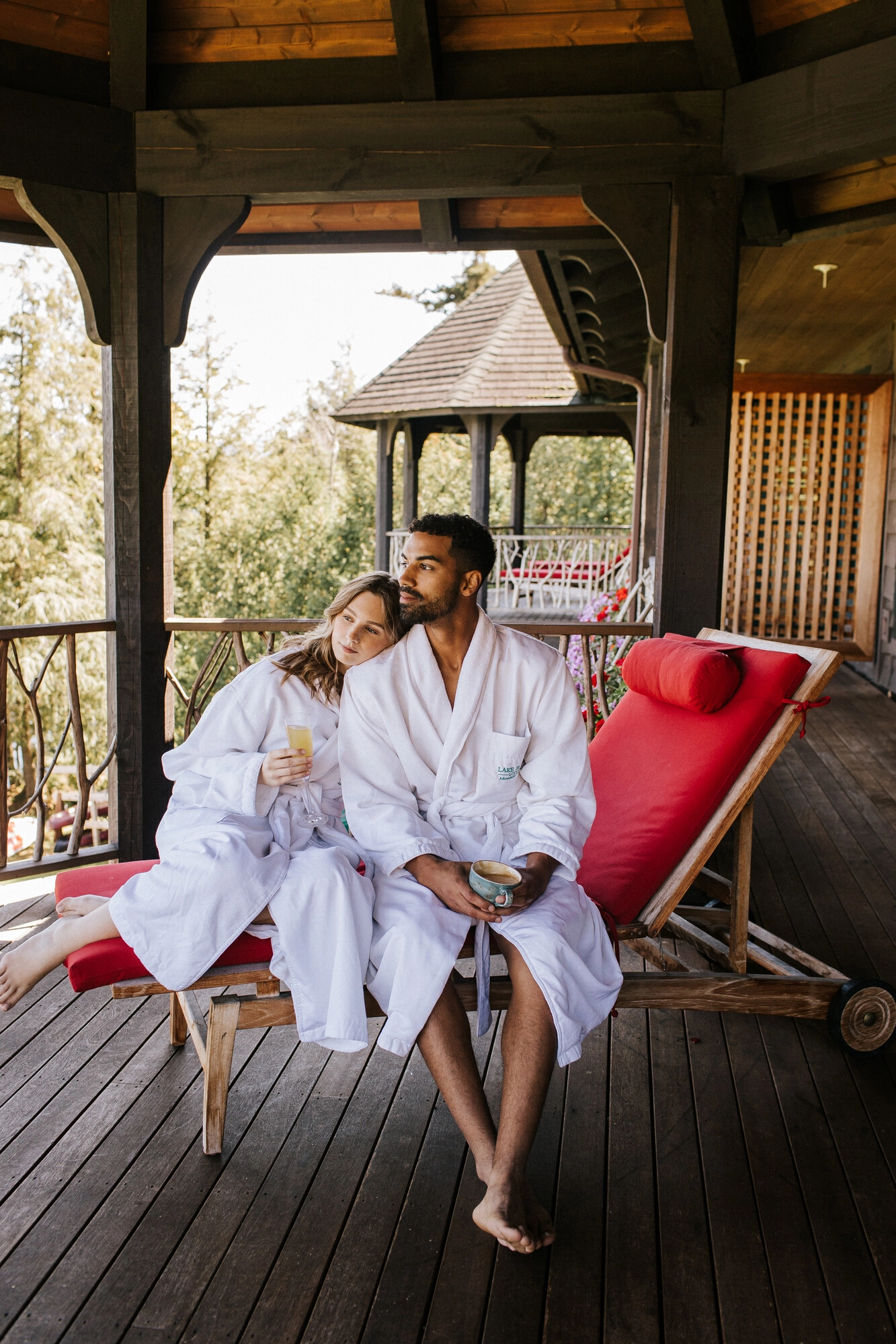 A man and woman sit in white robes at a resort. 