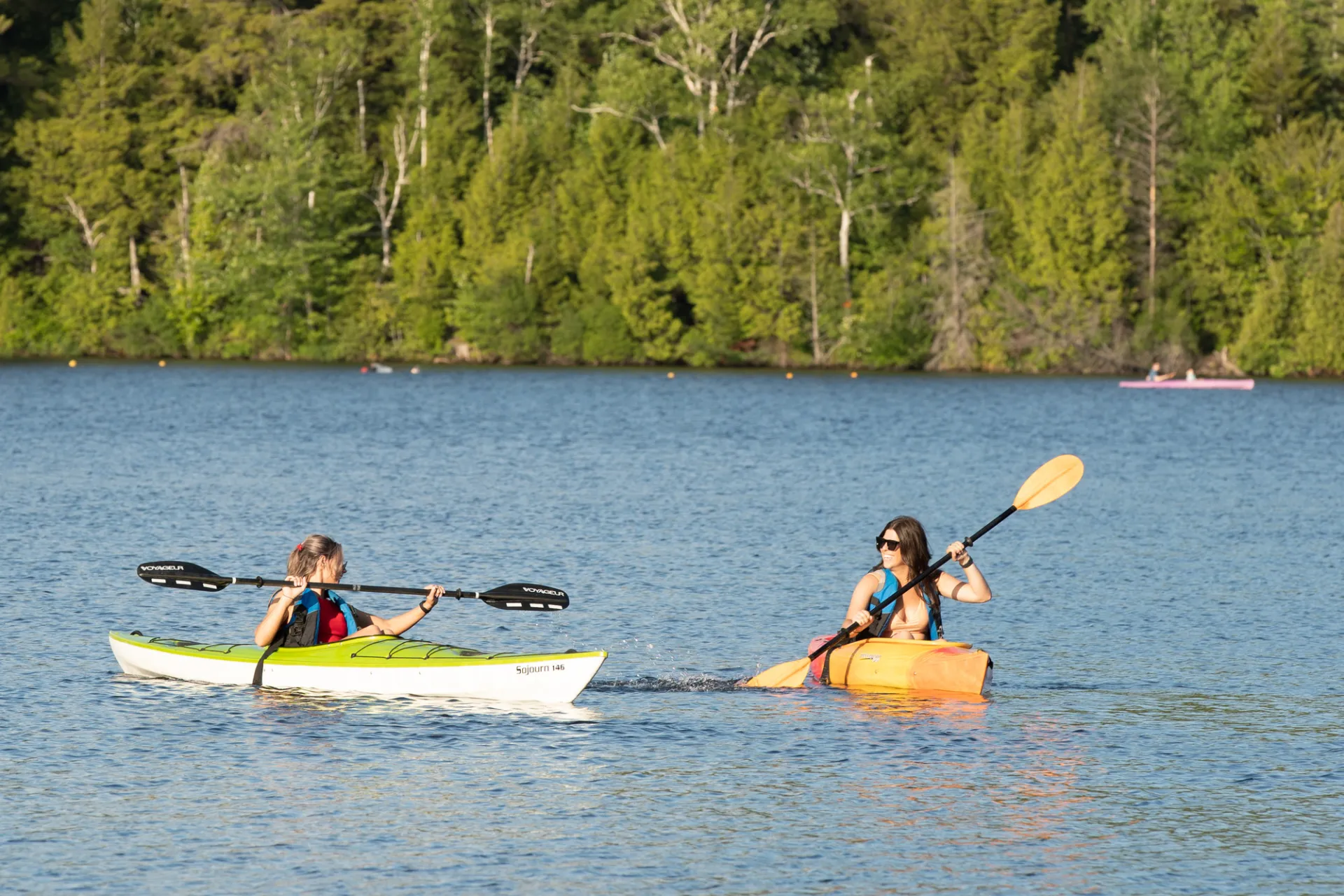 Two kayakers paddling on Mirror Lake in Lake Placid.