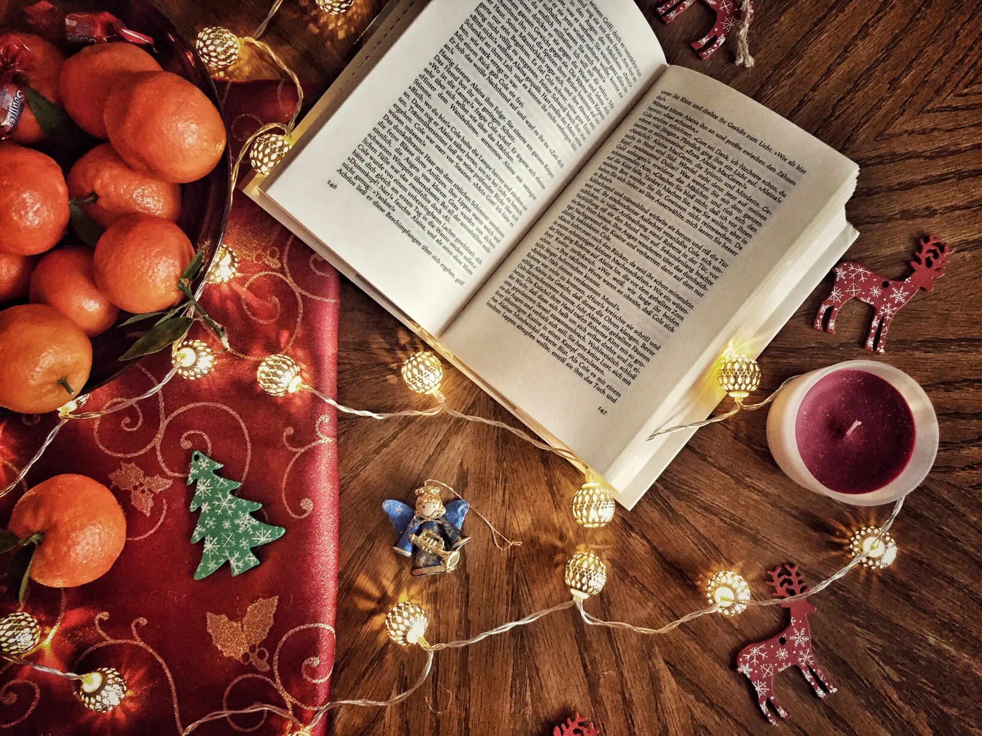 Stock photo of book open on wooden table surrounded by holiday decor