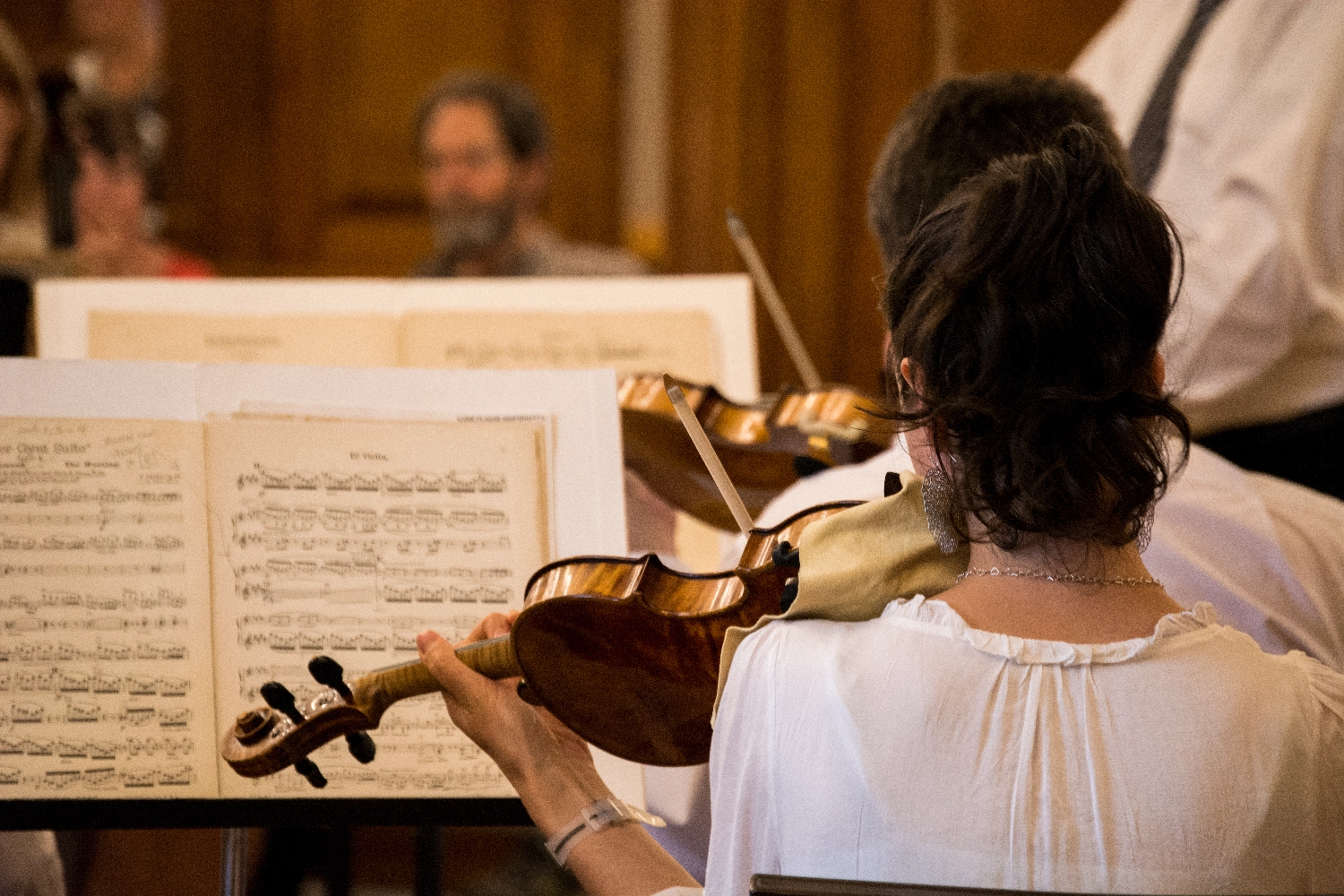 Woman reads music while playing violin