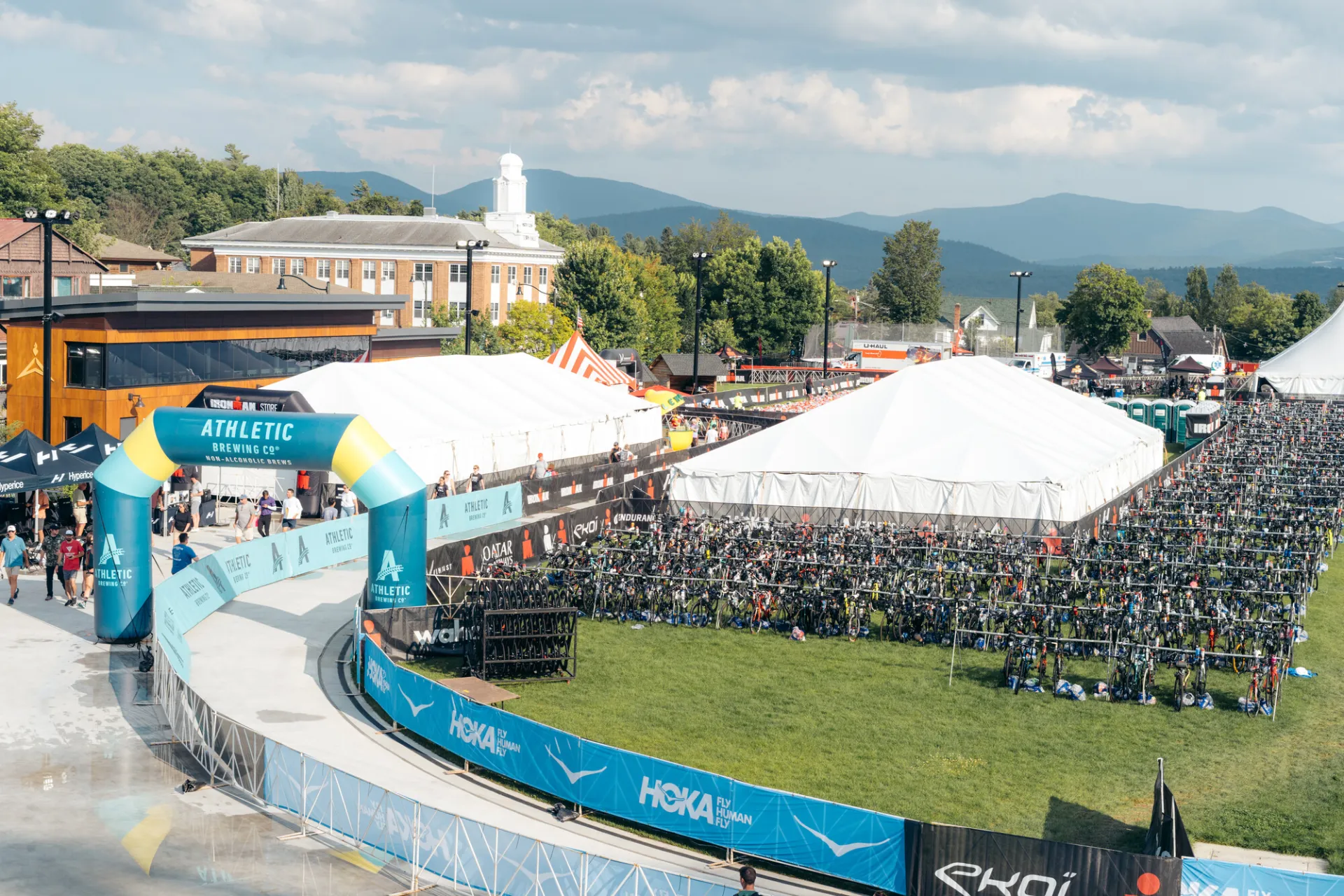 Image of the huge tents erected in the grassy center of the oval filled with bicycles and the view of the mountains in the distance.