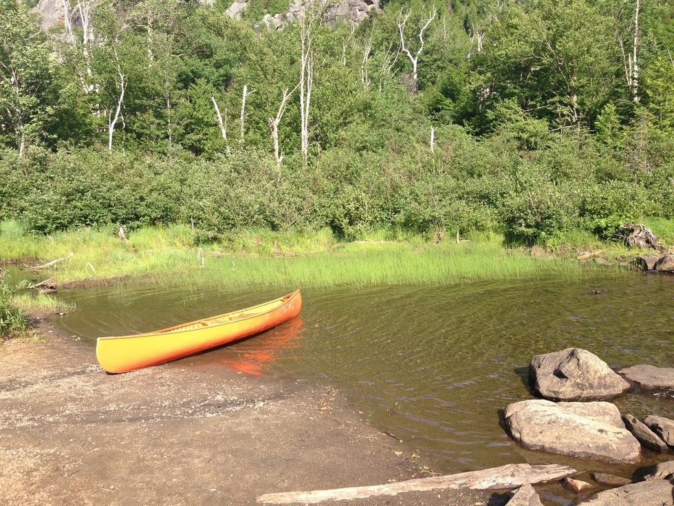 A canoe halfway in the water.