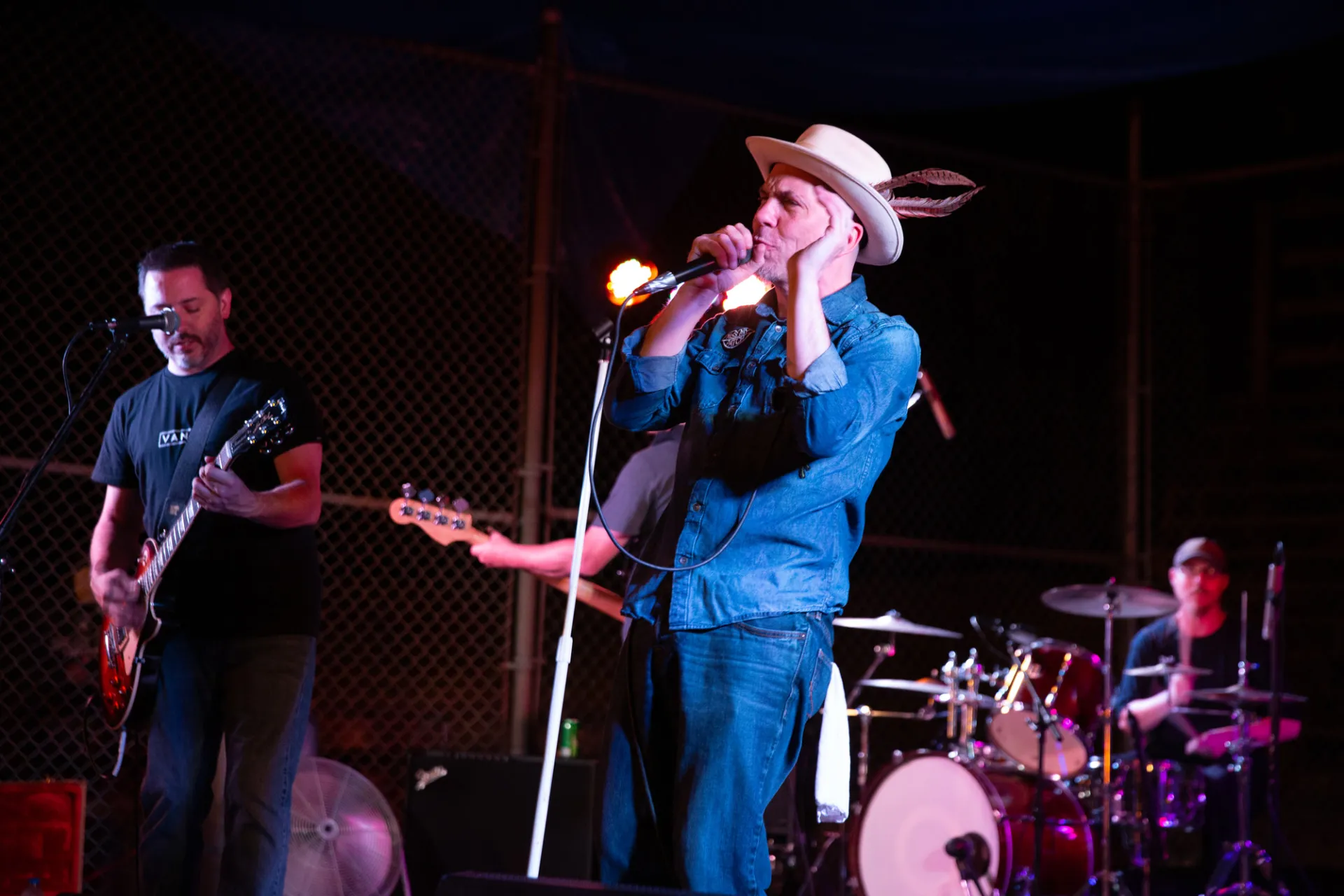 Band playing on stage with guitarist, singer and drums