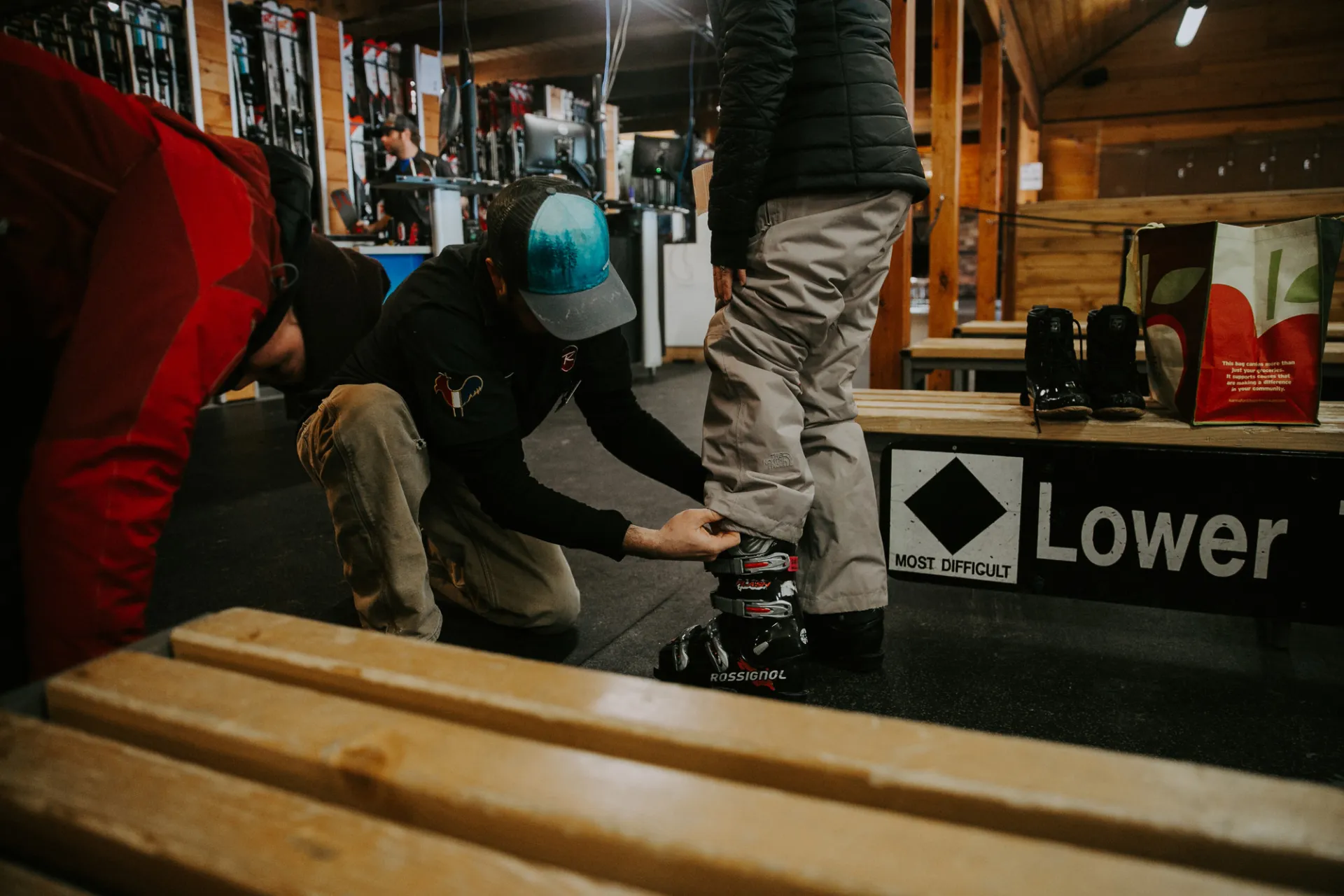 A ski tech helps someone fit a boot.