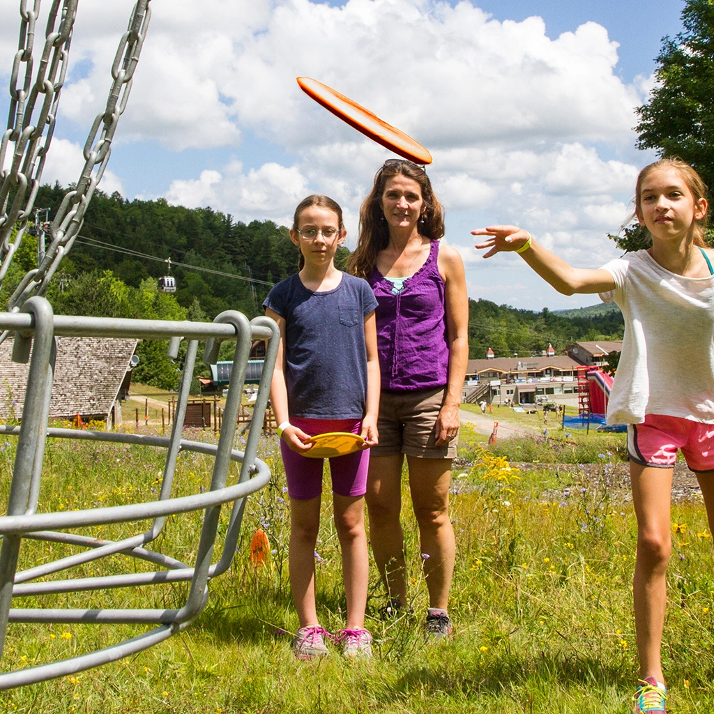 Kids throw disc golf frisbees at the next