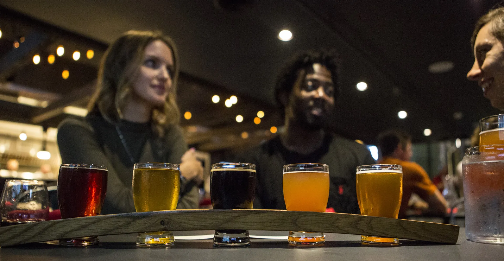 A flight of beer in front of a couple at Big Slide Brewery.