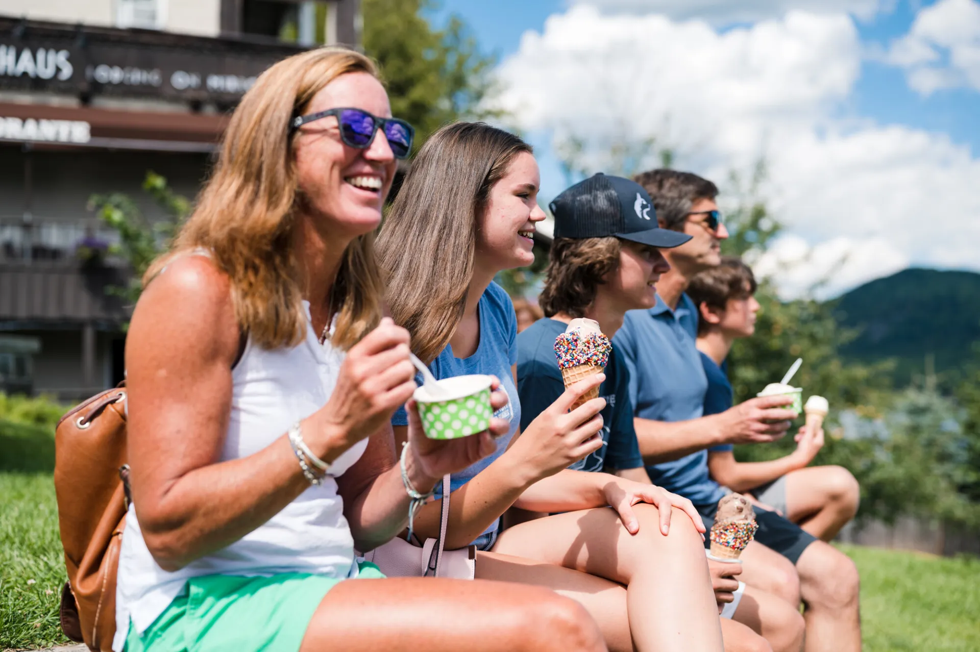 A family eating ice cream on a bench.