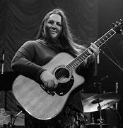 Black and white photo of a woman playing an acoustic guitar.
