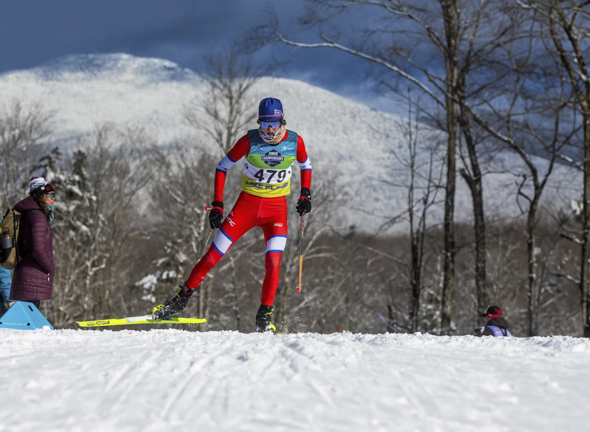 A cross-country skier races on a course on a snowy, sunny winter day.