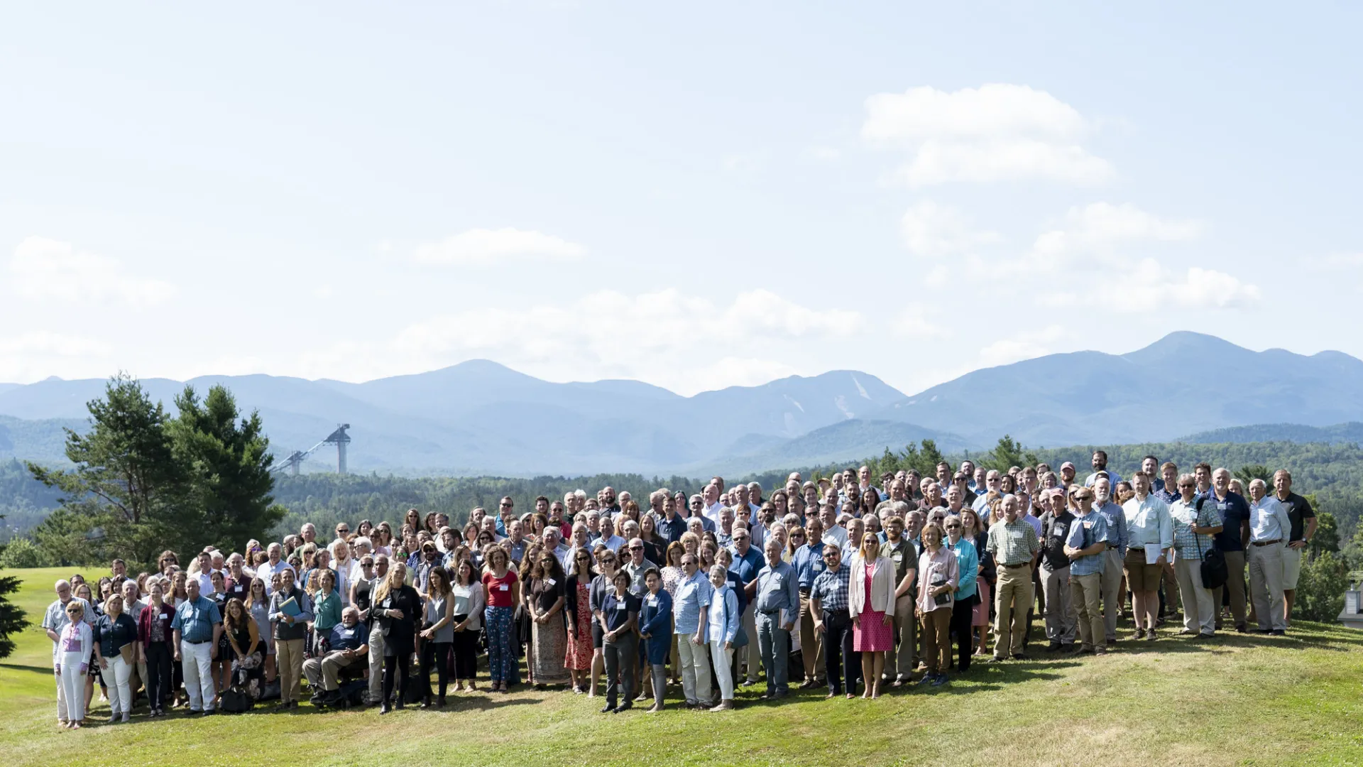 A group poses for a picture in front of mountains. 