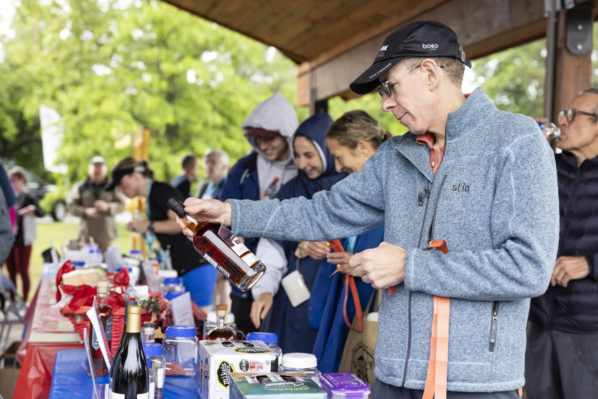 Racer looks at whiskey bottle from raffle