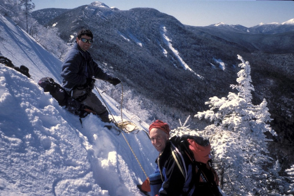 Two people look into the camera on a cross country ski trip.