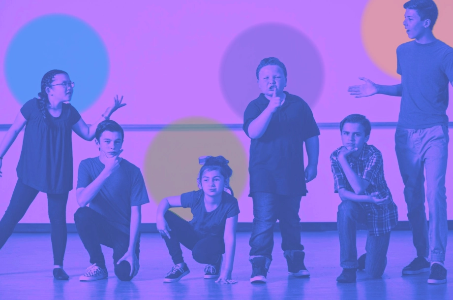 Six children in various poses, appearing to be acting or rehearsing a scene.