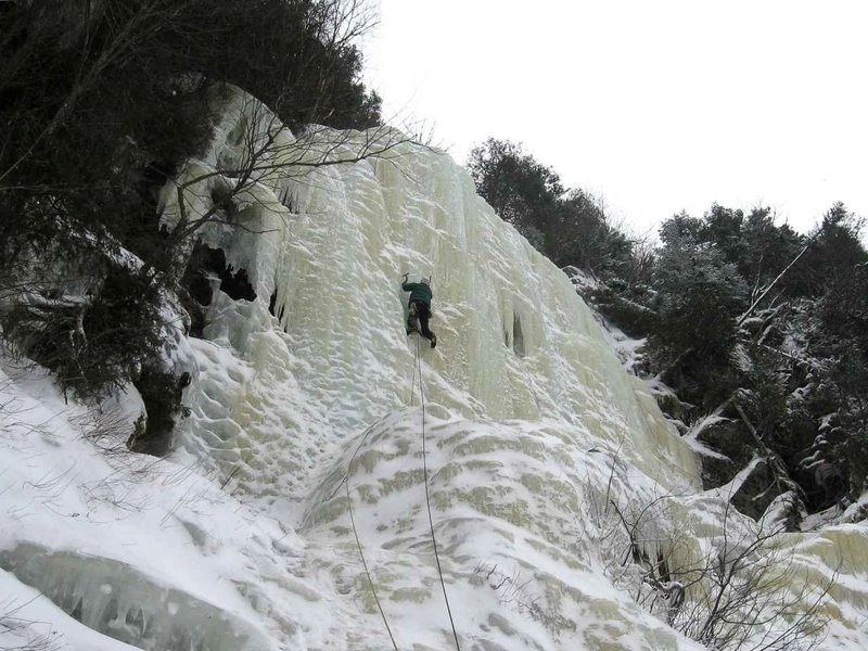 An ice climber leading up a headwall.