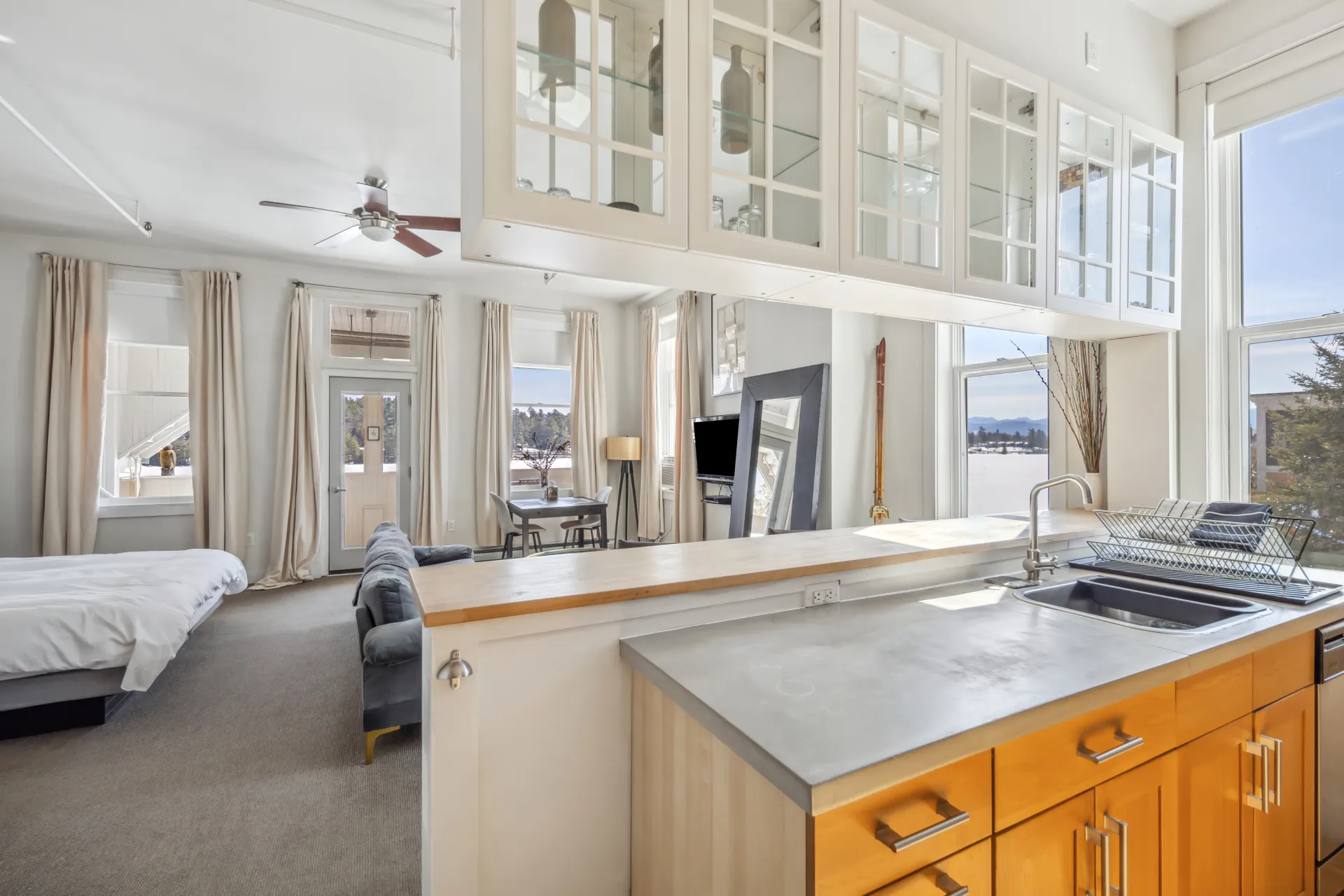 The view of the bedroom space with walls full windows overlooking Mirror Lake.