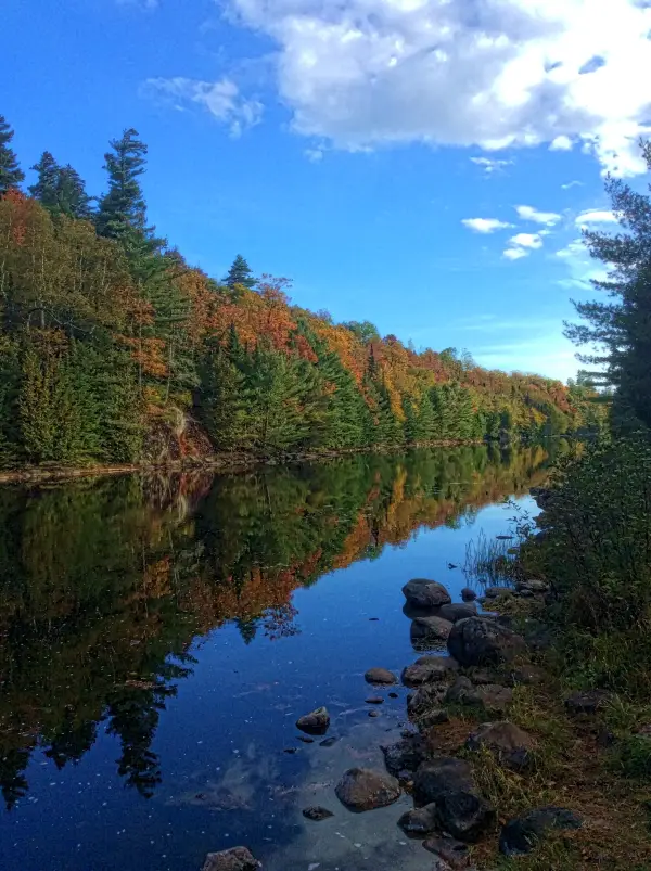 The road continues past the river, upstream of the dam.