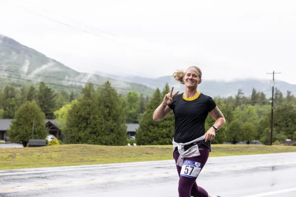 Racer smiles at camera with mountain in background