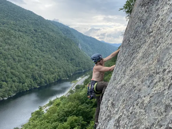 A person climbing above a scenic lake