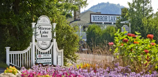 Image of the entry way with sign and glorious colorful summer flowers