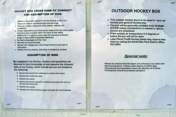 Two laminated papers explaining rules of a hockey box.