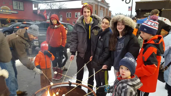 Group of young people roast marshmallows on Main Street.